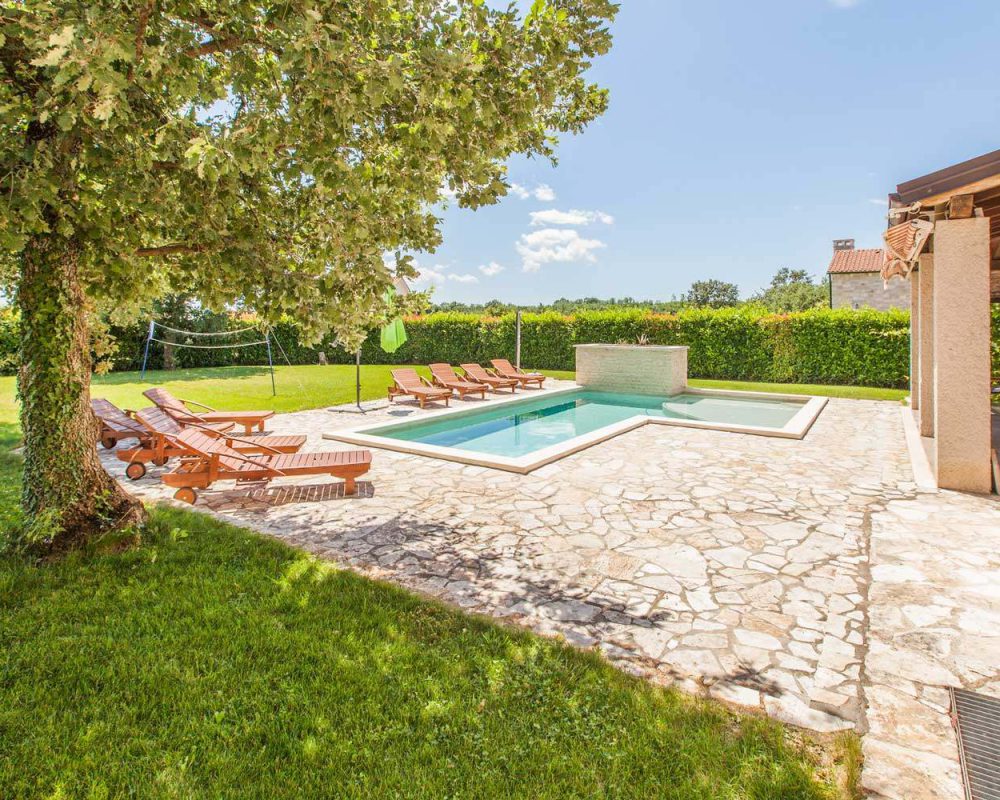 Auf der Terrasse ist ein 30m² großer Swimmingpool mit Acht schicken Sonnenliegen aus Holz.