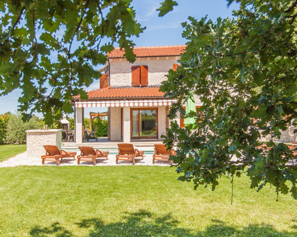 In dem grünen Garten der Villa Alma stehen drei große Bäume die Schatten spenden. Um ein entspanntes Sonnenbad zu nehmen gibt es Sonnenliegen auf der großen Terrasse.